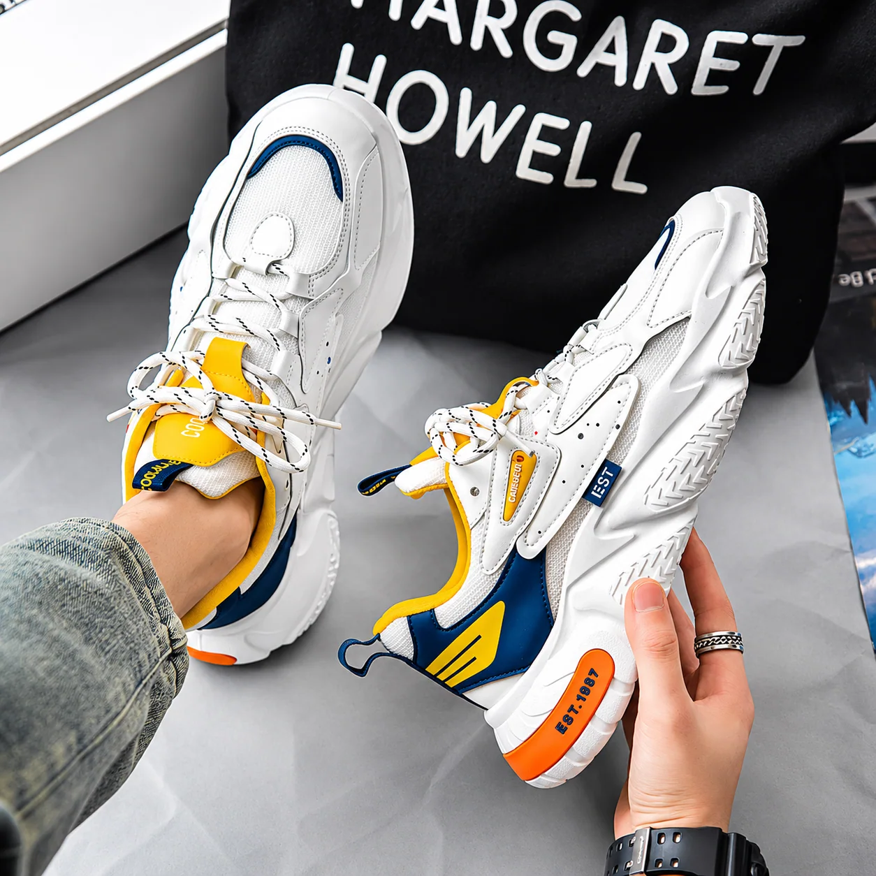 Sneakers blanches jaunes et bleu marine portées